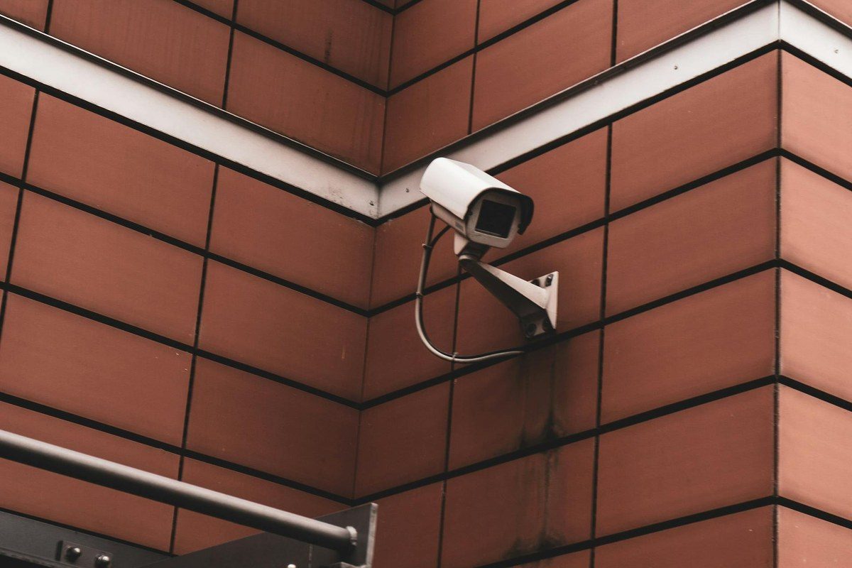 A security policy document with a pen on a table, with a gated community entrance visible through a window