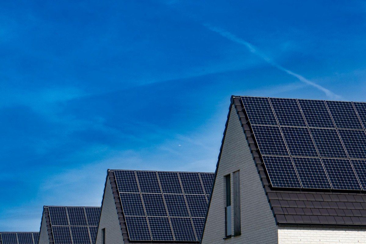 Solar panels installed on the roof of a Jamaican residential building with LED lighting visible in the common area below