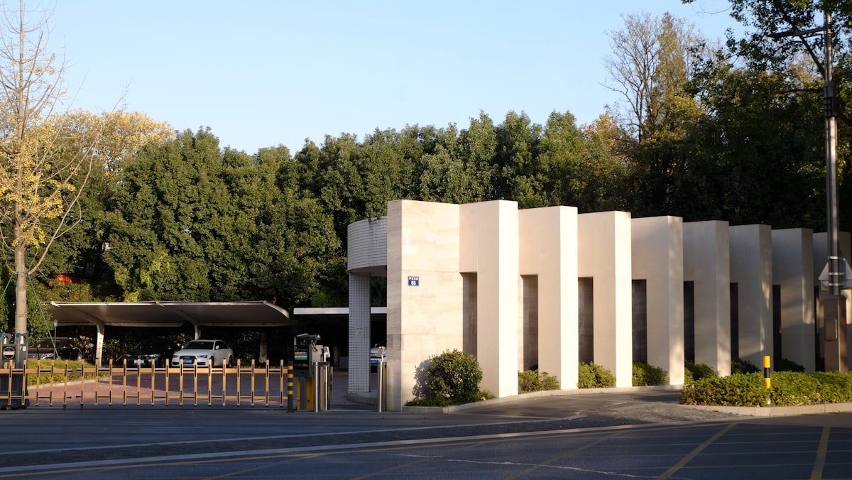 Vehicle following closely behind another car through a security gate